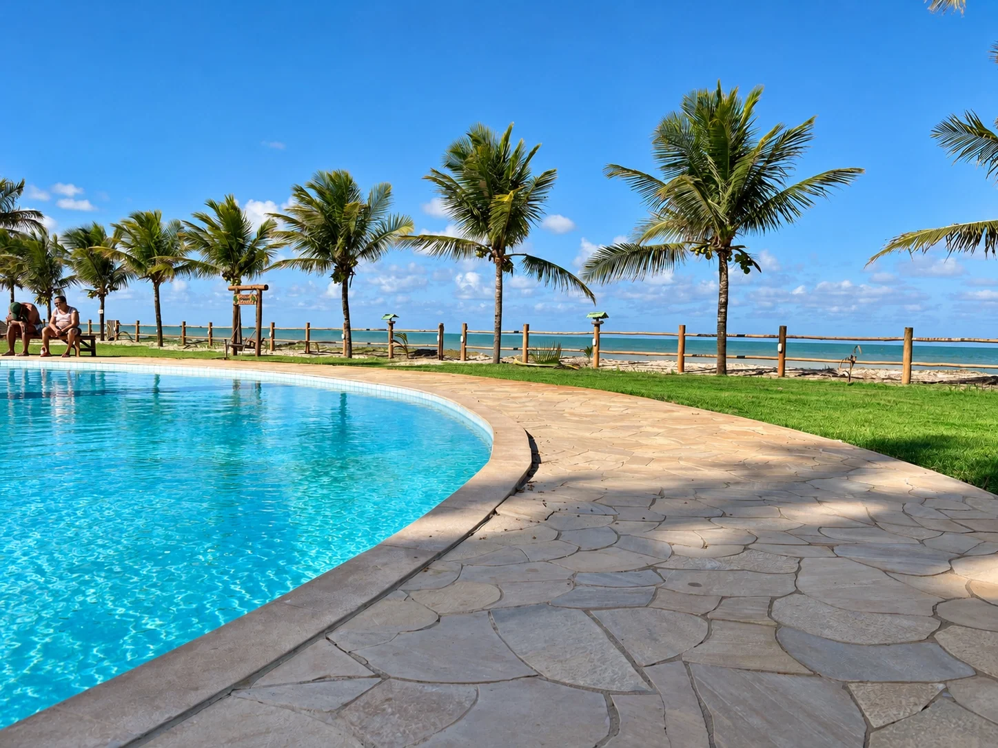 Piscina compartilhada do residencial, com vista para o mar